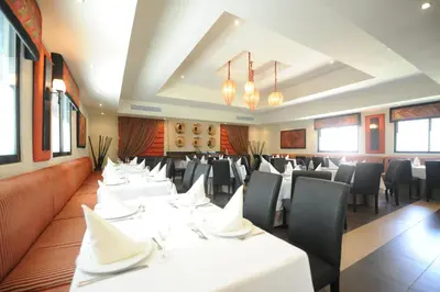 a dining room with white tables and black chairs at Blue JackTar in San Felipe de Puerto Plata