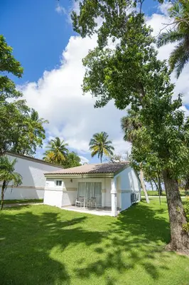 a white house with a tree in a yard at Blue JackTar in San Felipe de Puerto Plata