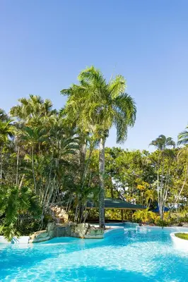 a swimming pool with palm trees in a resort at Blue JackTar in San Felipe de Puerto Plata