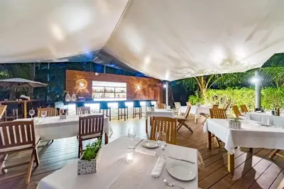 a dining room with white tables and chairs at Sublime Samana in Las Terrenas