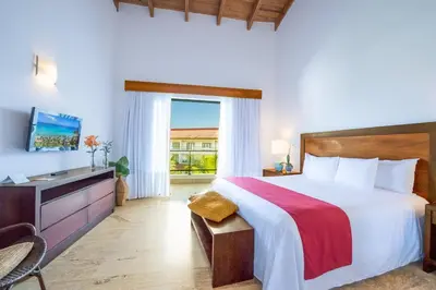 a bedroom with a bed and a desk and a television at Sublime Samana in Las Terrenas