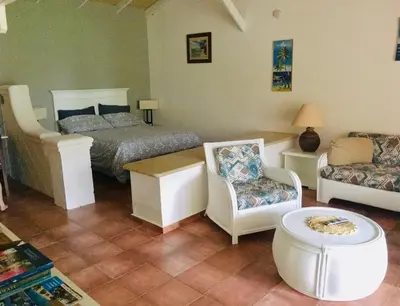 a bedroom with a bed and a couch and chairs at bungalow 3116 vue sur piscine in Las Galeras