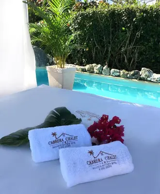a group of towels on a bed next to a swimming pool at Cabrera Chalet boutique hotel in Cabrera