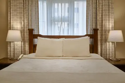 a bedroom with a bed with two lamps and two pillows at Hotel Riazor in Santo Domingo
