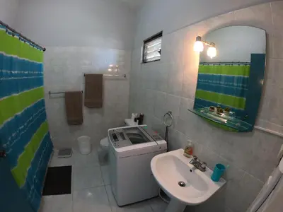 a bathroom with a sink and a toilet and a mirror at Lugo`s guest room in Punta Cana
