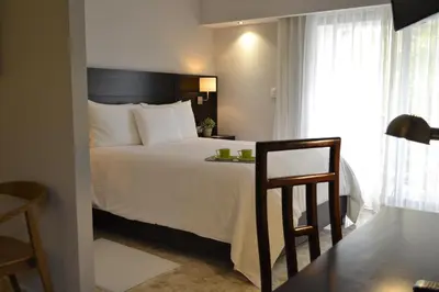 a bedroom with a bed and a table and a chair at Plaza Florida Suites in Santo Domingo