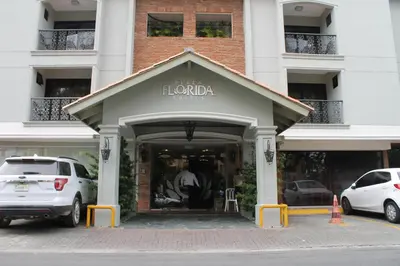 a store front of a building with cars parked outside at Plaza Florida Suites in Santo Domingo