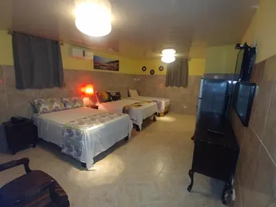 a hotel room with two beds and a couch at Hotel Riparbella in Santo Domingo