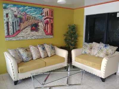two white couches sitting in a room with a painting at Hotel Riparbella in Santo Domingo