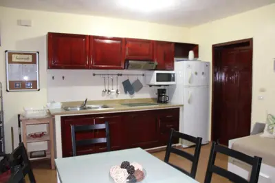 a kitchen with wooden cabinets and a white refrigerator at Apartamento B6 El Dorado en Bávaro - Punta Cana in Punta Cana