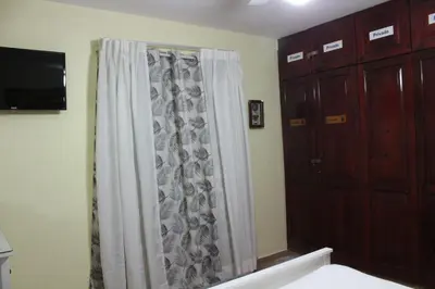 a bathroom with a shower curtain and a television at Apartamento B6 El Dorado en Bávaro - Punta Cana in Punta Cana