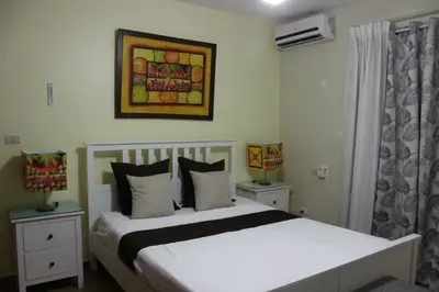 a bedroom with a white bed and a painting on the wall at Apartamento B6 El Dorado en Bávaro - Punta Cana in Punta Cana