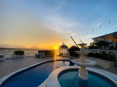 a swimming pool with a fountain in front of a sunset at Piergiorgio Palace Hotel in Sosúa