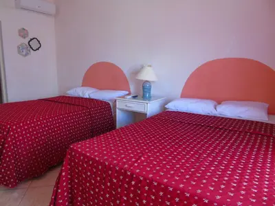 a hotel room with two beds with red sheets at Piergiorgio Palace Hotel in Sosúa