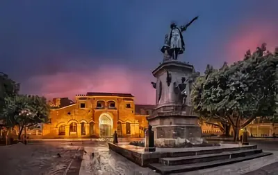 a building with a statue in front of it at Hotel Colonial Blanco in Santo Domingo