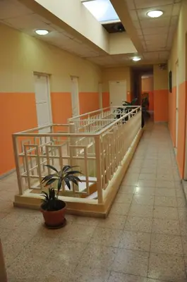 a hallway with a staircase in a building with a plant at Hotel Colonial Blanco in Santo Domingo