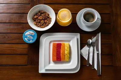 a table with a plate of cake and a cup of coffee at Hotel Villa Colonial in Santo Domingo
