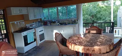a kitchen with a table with chairs and a kitchen with a tableablish at Los Palmares Guest House & Eventos in San Cristóbal