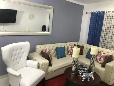 a living room with a couch and a chair at lujoso apto con terraza para barbecue in Santiago de los Caballeros