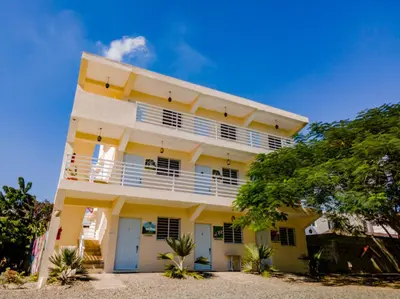 a yellow and white building with trees in front of it at Hotel Anedi in Concepción de La Vega