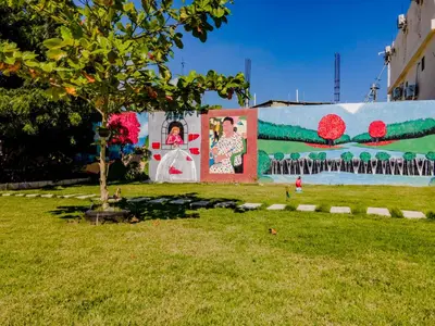 a mural on a building with a tree in the grass at Hotel Anedi in Concepción de La Vega