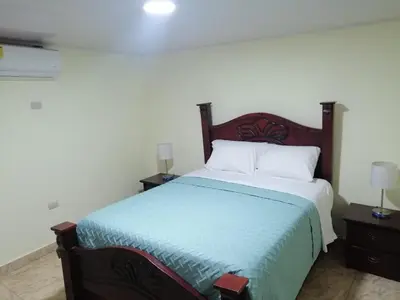 a bedroom with a bed and two night stands with two lamps at Hotel Anedi in Concepción de La Vega