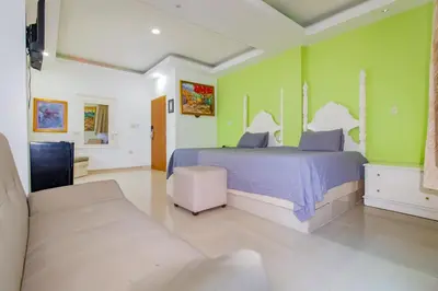 a bedroom with a bed and green walls at Hotel La Casona Dorada in Santo Domingo
