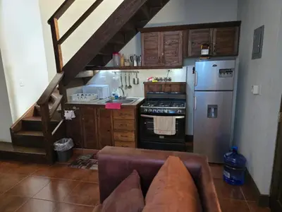 a kitchen with a staircase leading to a kitchen with a refrigerator at Ximenoa Rivers Villa Relax in Jarabacoa