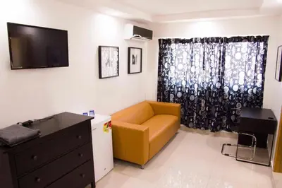 a living room with a yellow couch and a television at City Caribbean Hotel Boutique in Santo Domingo