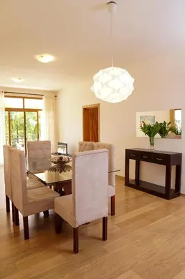 a dining room with a table and chairs and a chandelier at Sybaris Suites & Residences in Juan Dolio