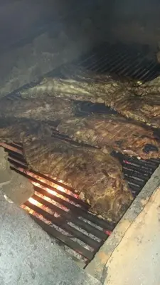a bunch of meat cooking on a grill at La famosa costillas a la leña in Jarabacoa