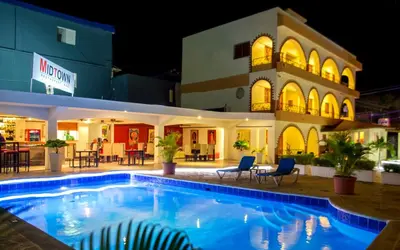 a pool in front of a hotel at night at Hotel Las Palmeras in Sosúa