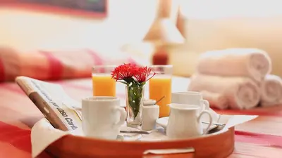 a tray with cups and a vase of flowers on a table at Hotel Las Palmeras in Sosúa