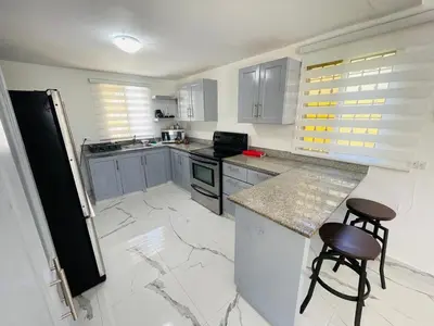 a kitchen with a counter and two stools in it at Playa Dorada Mountainview Villa in San Felipe de Puerto Plata