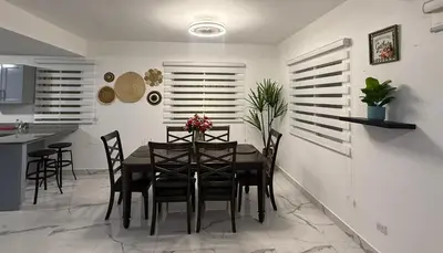 a dining room with a black table and chairs at Playa Dorada Mountainview Villa in San Felipe de Puerto Plata