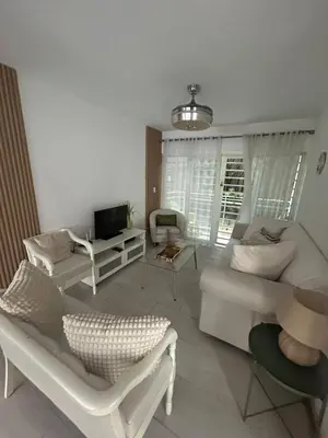 a living room with a white couch and a tv at Beautiful & Comfortable Apartment near Colonial Zone in Santo Domingo