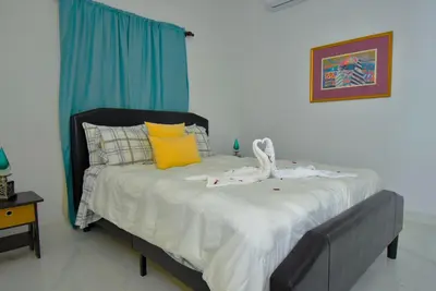 a bedroom with a bed with a blue curtain at Rosil Place in San Felipe de Puerto Plata