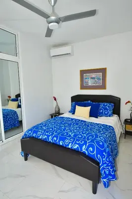 a bedroom with a bed with blue sheets and a ceiling at Rosil Place in San Felipe de Puerto Plata