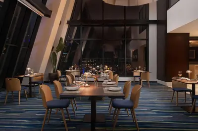 a restaurant with tables and chairs and a large window at Homewood Suites By Hilton Santo Domingo in Santo Domingo