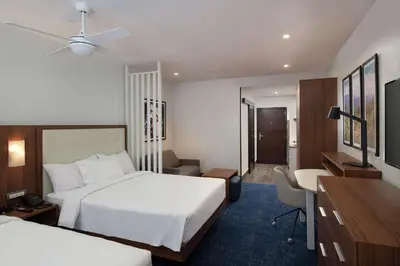 a hotel room with two beds and a desk at Homewood Suites By Hilton Santo Domingo in Santo Domingo