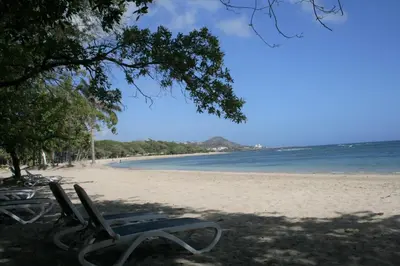 a beach with two lounge chairs and the ocean at Villa Deluxe Costambar in San Felipe de Puerto Plata