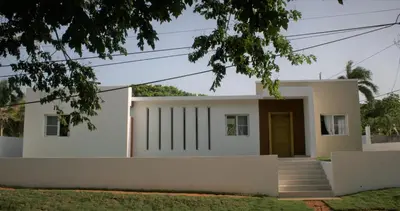a house with white walls and a door at Villa Deluxe Costambar in San Felipe de Puerto Plata