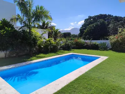 a swimming pool in the yard of a house at Villa Deluxe Costambar in San Felipe de Puerto Plata
