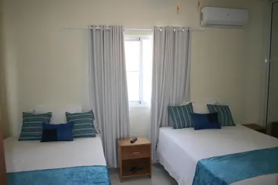 a bedroom with two beds and a window at Villa Deluxe Costambar in San Felipe de Puerto Plata