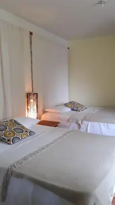 a bedroom with two beds and a lamp in it at Hotel Magic Tropical in Boca Chica