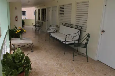 a porch with a couch and chairs and a table at Hotel Magic Tropical in Boca Chica