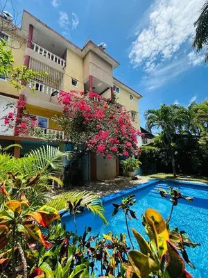 a resort with a swimming pool in front of a building at Apartmenthotel Michaela in Sosúa