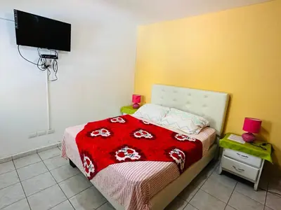 a bedroom with a bed with a red blanket at Apartmenthotel Michaela in Sosúa