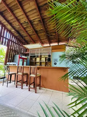 a restaurant with a bar with chairs and a counter at Apartmenthotel Michaela in Sosúa