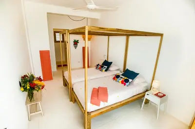 a bedroom with a wooden canopy bed with pillows at Casa Blava with AC in Las Galeras